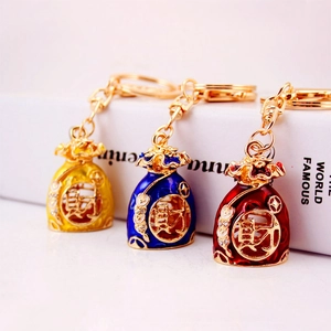 Three Chinese fortune bag keychains in yellow, blue, and red with gold lucky character