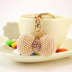 Elegant white faux pearl bow keychain with sparkling rhinestones and golden metal ring