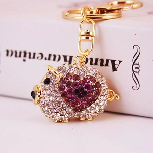 Cute piggy keychain with white and purple crystals on golden metal lobster clasp base