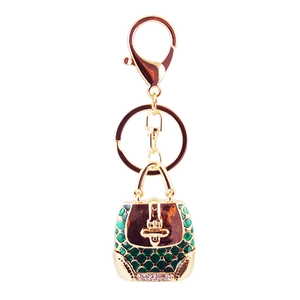 Green enamel handbag keychain with gold finish, sparkling crystals, and planetary charm