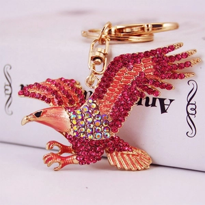 Porte-clés aigle créatif avec strass rose rouge et placage d'or sur un fond de livre