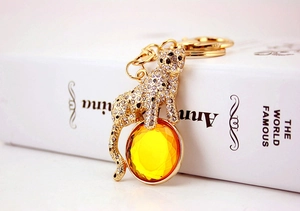 Detailed macro view of a gold leopard keychain with crystal rhinestones and yellow gemstone