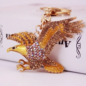 Porte-clés aigle doré orné de strass marron étincelants et de détails en cristal fins