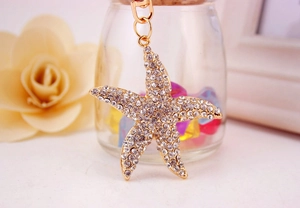 Close-up of golden starfish keychain charm with sparkling rhinestones and lobster clasp