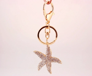 Close-up of gold starfish keychain with sparkling rhinestones and lobster clasp detail