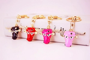 Detail of four colorful bull head keychains with rhinestones and enamel on a book