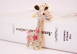 Detailed close-up of a gold giraffe keychain with sparkling pink and white crystals