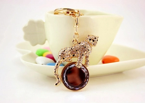 Detail of crystal leopard keychain with large coffee-colored faceted gemstone and gold finish