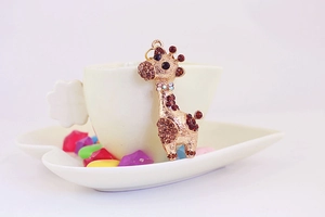 Détail macro d'un pendentif girafe doré avec des cristaux marron et champagne brillants