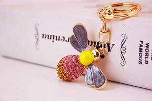 Detailed macro view of crystal bee keychain with pink rhinestones and gold hardware