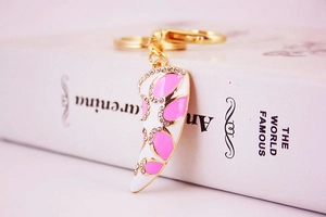 Detail of pink and white horn keychain with sparkling rhinestones on golden metal base