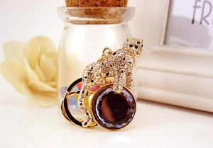 Macro view of gold leopard keychain with crystal pavé and purple gemstone detail