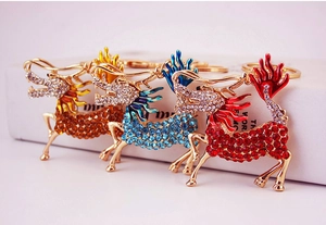 Detailed view of three colorful Chinese kylin keychains with crystal inlay and enamel finish