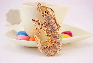Detail of sparkling lobster keychain featuring inlaid rhinestones on golden metal base