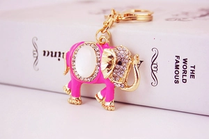 Detail of pink elephant keychain with gold metal frame, opal stone and sparkly crystals