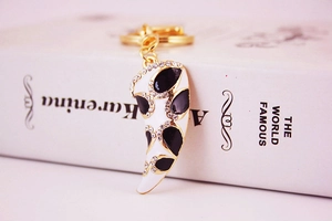 Detail of creative horn instrument keychain with sparkling crystals on vintage book