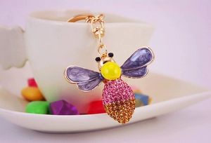 Detail of bee keychain with purple enamel wings and pink rhinestone crystal abdomen