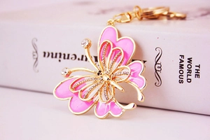 Détail du porte-clés papillon en émail rose avec des strass blancs étincelants