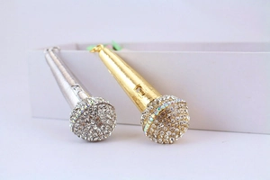 Detailed view of silver and gold microphone keychains with sparkling rhinestones