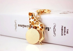 Detailed close-up of golden leopard keychain with rhinestones resting on a white book