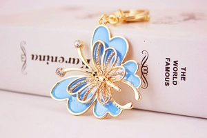 Détail d'un porte-clés papillon coloré avec émail bleu et cristaux scintillants
