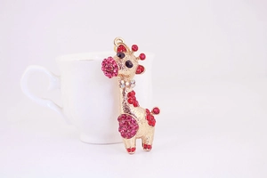 Détail du porte-clés girafe en cristal avec strass roses sur une base en métal doré