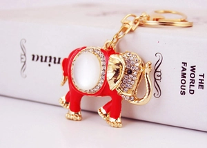 Close-up of golden elephant keychain with red enamel and sparkling crystal details