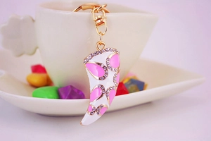 Detail of horn instrument keychain with white enamel, pink pattern and sparkling crystals