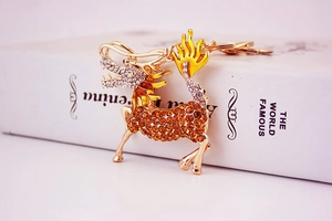 Detailed macro view of gold-plated mythical kylin keychain with amber rhinestones