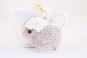 Macro shot of sheep keychain with sparkling rhinestones and white enamel finish