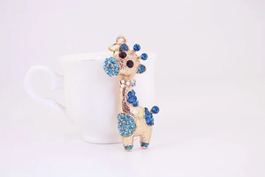 Détail du porte-clés girafe en alliage doré orné de strass en cristal bleu brillant