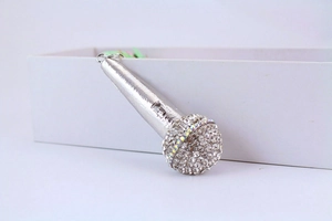 Detailed close-up of a silver microphone keychain pendant with white rhinestones