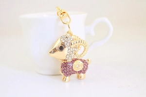 Dettaglio del portachiavi a capra dorata con strass bianchi e viola scintillanti