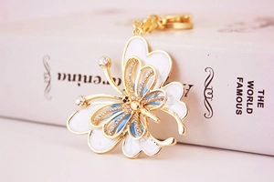 Détail d'un porte-clés papillon coloré avec strass et fermoir mousqueton en métal doré
