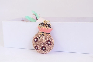 Détail du pendentif sac de fortune avec strass roses et finitions en émail doré