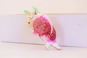 Detailed view of pink rhinestone fish keychain with gold lobster clasp on white box