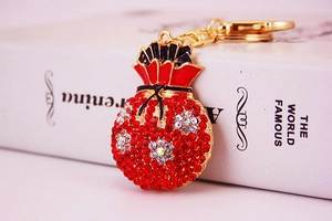 Detail of red rhinestone lucky money bag keychain with gold plating and floral pattern