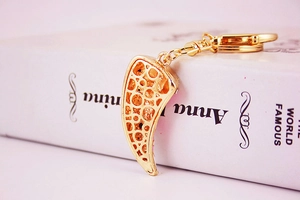 Detail of golden horn keychain showing intricate hollowed-out patterns on the metal pendant