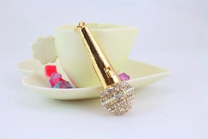 Detail of creative golden microphone keychain featuring sparkling rhinestones and metal ring