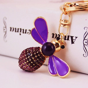 Golden bee keychain with purple enamel wings and sparkling crystal rhinestones