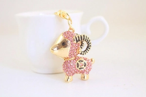 Dettaglio del portachiavi a forma di capra con strass rosa e base in metallo dorato