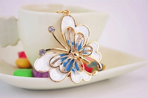 Détail d'un porte-clés papillon double couche avec émail bleu et strass brillants