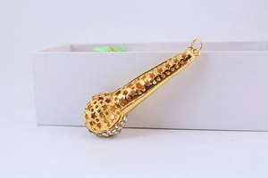Close-up of gold microphone keychain featuring star hollow carvings and tiny rhinestones