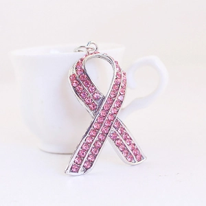 Portachiavi con nastro di strass rosa brillante appoggiato a una tazza di caffè bianca