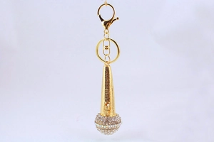 Close-up of golden microphone keychain featuring sparkling rhinestones and metal lobster clasp