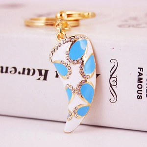 Creative horn-shaped gold keychain with white enamel, blue patterns and shiny rhinestones