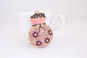 Détail du pendentif sac de fortune avec cristaux blancs et fleurs en émail rose