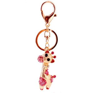 Porte-clés girafe en or rose avec strass roses et fermoir mousqueton sur fond blanc éclatant