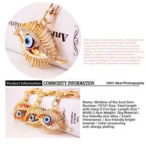 Detail view of crystal Evil Eye keychain featuring golden eyelashes and blue enamel pendant