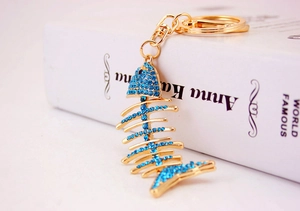 Detailed close-up of fishbone keychain with blue crystals and golden alloy finish